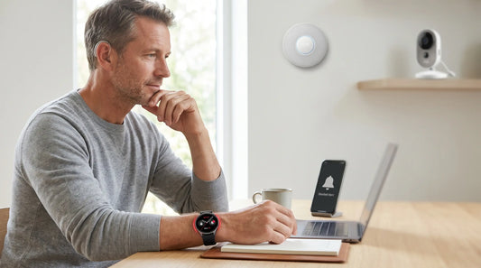 Man with hearing aid receives doorbell alerts on his smartwatch and phone in a smart home with integrated security.