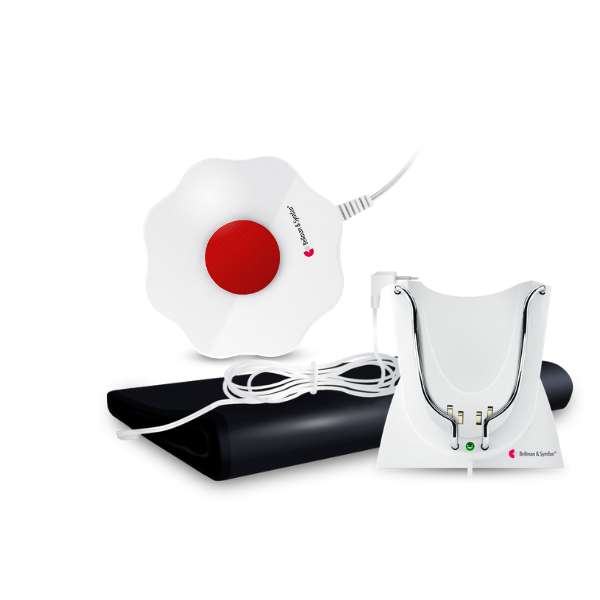 A set of bedwetting alarm components including a flower-shaped sensor with a large red button, a white charging base, and a black sensor mat.